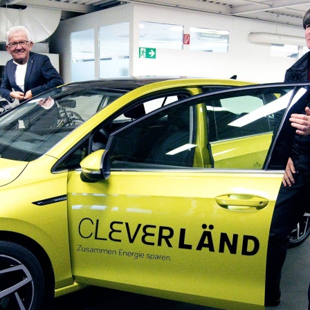 Kretschmann und Jogi Löw stehen vor Auto mit Cleverländ-Aufdruck