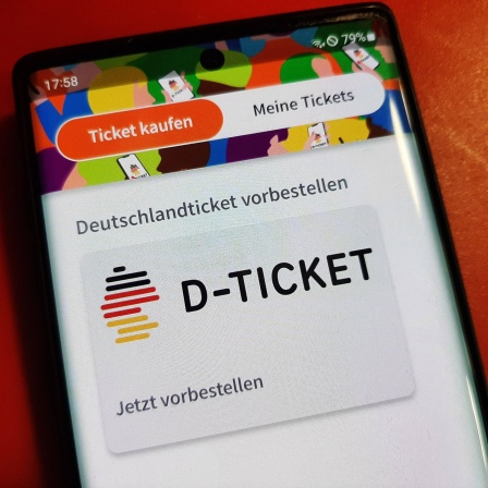 Der Bildschirm eines Mobiltelefons zeigt das Logo des "Deutschlandtickets".