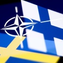 Die Flaggen der NATO, von Schweden und Finnland auf einem Bildschrim dargestellt (Bild: picture alliance / NurPhoto)