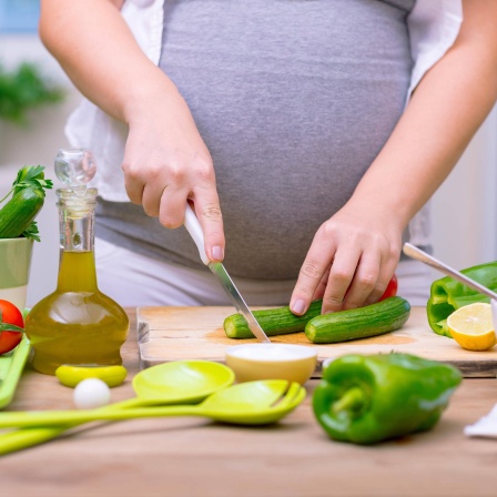 Eine Schwangere bei der Zubereitung von Essen