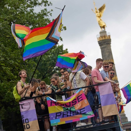Menschen feiern auf einem Wagen beim 46. Berlin Pride Umzug zum Christopher Street Day (CSD) in Sichtweite der Siegessäule.