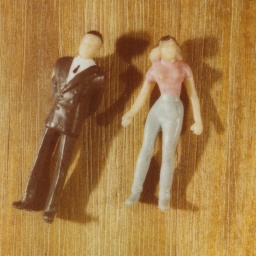 Zwei Spielfiguren, die Mann und Frau darstellen, liegen auf dem Boden.