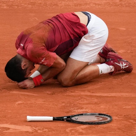 Novak Djokovic liegt verletzt am Boden während der French Open