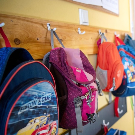 Ein Flur im Kindergarten mit zwei Kindern und einer Betreuerin.