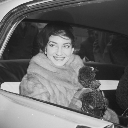 Eine lächelnde Maria Callas im Auto mit ihrem Pudel "Toy"