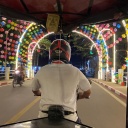 Ein Tuk Tuk Fahrer von hinten fährt über eine Brücke in Siem Reap 