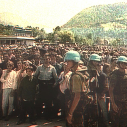 Der Screenshot vom niederländischen Fernsehen zeigt holländische UN-Soldaten vor hunderten von muslimischen Zivilisten, die aus dem nahegelegenen Srebrenica vor serbischem Terror geflüchtet waren. Unter Leitung von General Mladic hatten die Serben die damalige UN-Schutzone am 11. Juli 1995 eingenommen. Die niederländischen Blauhelme Dutchbat hatten den Angreifern die Enklave kampflos überlassen.