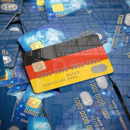 Illustration einer Kreditkarte mit den deutschen Nationalfarben, die auf einem Haufen anderer Kreditkarten liegt.
