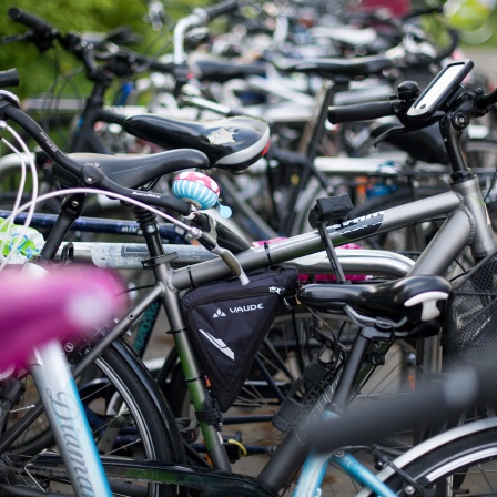 Zahlreiche Fahrräder - manche mit Computern für den Antrieb oder die Navigation - sind an einem Fahrradständer abgestellt.