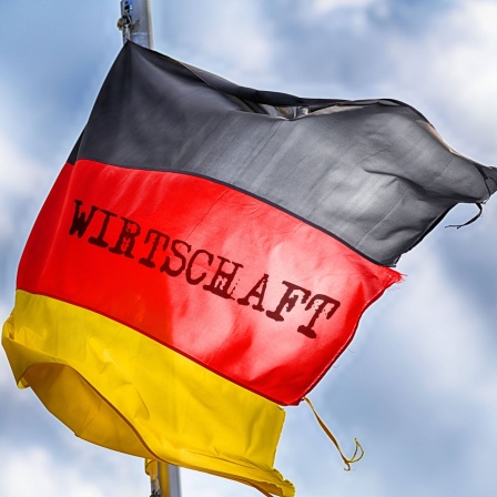 FOTOMONTAGE, Zerschlissene Deutschlandfahne im Wind mit Aufschrift Wirtschaft