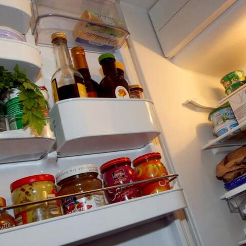 Blick in einen offenen, gut gefüllten Kühlschrank