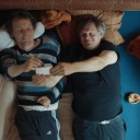 Filmszene aus Bruderliebe: Markus und Michael liegen nebeneinander vergnügt im Bett.