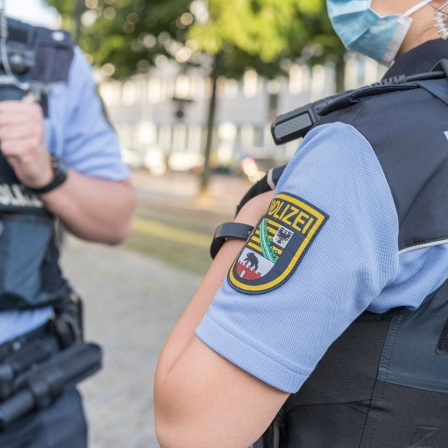 Ein Mann und eine Frau in Uniformen der Polizei Sachsen-Anhalt unterhalten sich