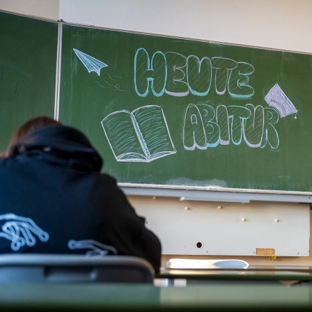 "Heute Abitur" steht auf einer Tafel im Klassenzimmer eines Gymnasiums.