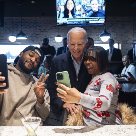 Joe Biden (M), Präsident der USA, macht während eines Wahlkampfstopps Fotos mit Gästen in einem Restaurant. Archivbild: 01.02.2024
