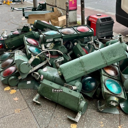 An einer Berliner Straßenecke lagern zahlreiche demontierte Verkehrsampeln.