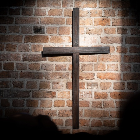 altes Holzkreuz in der Marktkirche in einem Sonnenfleck an der Wand