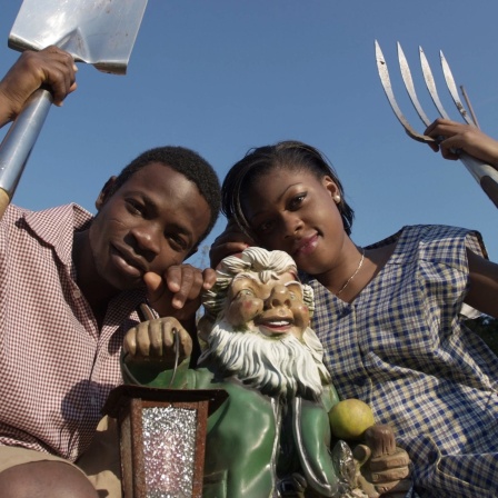 Ein junges Paar aus Afrika stammend in einem typisch deutschen Schrebergarten.