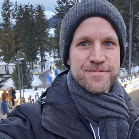 Ein Portraitbild von NDR Info Redakteuer Arne Schulz auf dem Weltwirtschaftsforum 2025 in Davos, Schweiz
