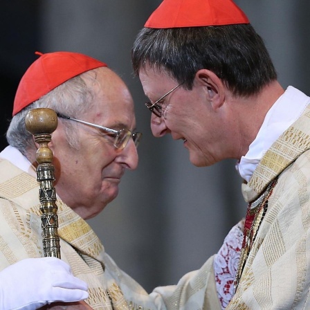 Der Kölner Erzbischof Rainer Maria Woelki (r) nimmt am 20.09.2014 in Köln von seinem Vorgänger Kardinal Joachim Meisner (l) den Petrusstab entgegen