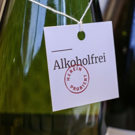 An einer Weinflasche hängt ein Eitikett "Alkoholfrei - hereinprobiert".