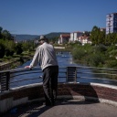 A Kosovo Albanian man looks the Ibar river from a bridge in the town of Mitrovica, on September 19, 2022. - In the deeply divided city of Mitrovica 