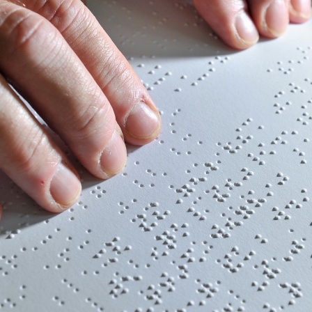 Ein Mitarbeiter der Deutschen Zentralbücherei für Blinde (DZB) in Leipzig, liest einen Roman in Brailleschrift Korrektur.