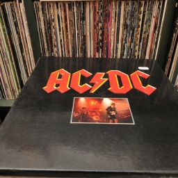 Vinylplatte von AC/DC auf einem Plattenstapel im Schallplattenladen