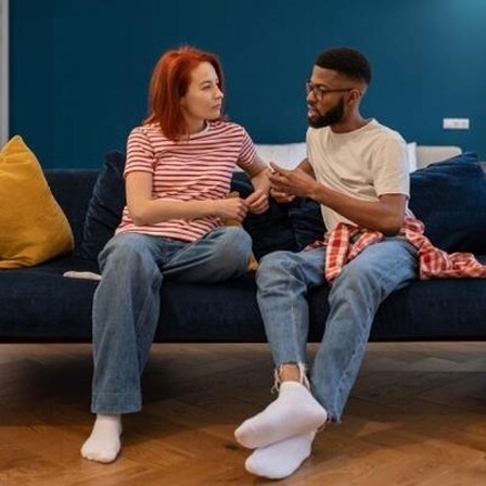 Eine Frau und ein Mann sitzen auf dem Sofa und unterhalten sich