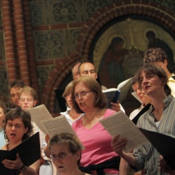 Mitglieder eines Kirchenchores proben in einer Kirche.