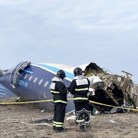 Mitarbeiter des Ministeriums arbeiten an der Absturzstelle des Flugzeugs der Azerbaijan Airlines, das von Baku nach Grosny flog, auf dem Flughafen Aktau im Westen Kasachstans.