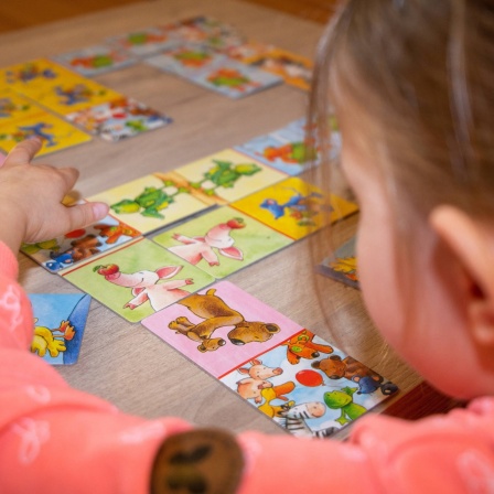 Mädchen spielt mit Bildkarten: Die Sprach-Kitas gelten als sehr erfolgreich, damit kleine Kinder gut Deutsch lernen können. Trotzdem soll das Programm Mitte 2023 auslaufen. Wie geht es weiter mit der Sprachbildung?