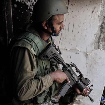 Ein israelischer Soldat steht in der Nähe eines zerstörten Hauses Wache.