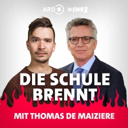 Thomas de Maizière und Bob Blume vor Flammen