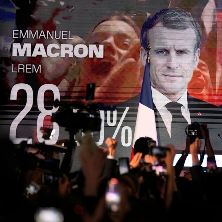 Ein Bildschirm zeigt den französischen Präsidenten Macron und die rechtsextreme Kandidatin Le Pen am Wahltag