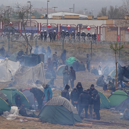 Migranten stehen zwischen Zelten im Lager in der Sicherheitszone © Ulf Mauder/dpa