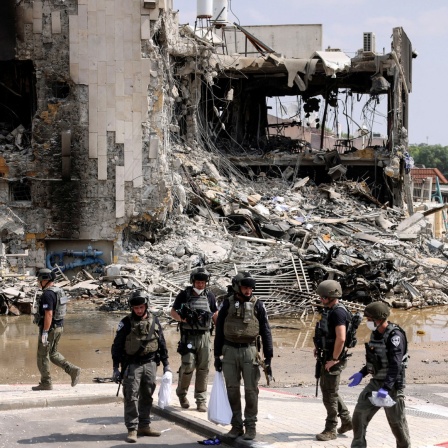 Israelische Sicherheitskräfte versammeln sich nach Angriffen militanter Palästinenser vor einem zerstörten Gebäude in der Grenzstadt Sderot.