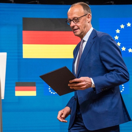 Bundeskanzler Friedrich Merz (CDU) geht vor Beginn der Pressekonfernez im EU-Hauptquartier in Brüssel zum Sprecherpult. 