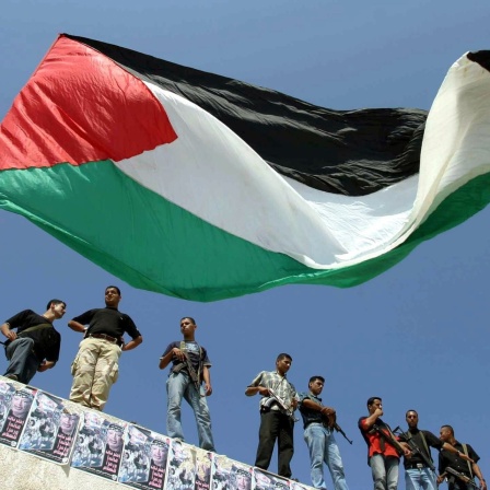 Militante Palästinenser und Fatah-Aktivisten stehen am 28.9.2003 während einer Demonstration in Gaza-Stadt im Gazastreifen auf dem Dach eines Gebäudes. Im Vordergrund weht eine palästinensische Flagge.