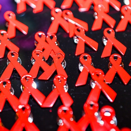 Aids-Schleifen liegen als Anstecknadeln auf einem Tisch.