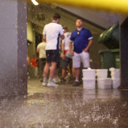 Fußball-Fans bei der EM schützen sich vor dem Regen