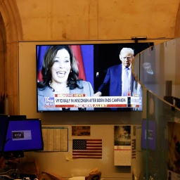 Auf einem TV-Bildschirm sind Kamala Harris und Donald Trump zu sehen. 