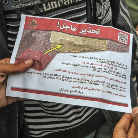 Palästinenser halten ein Flugblatt in der Hand, das von einem Militärflugzeug der israelischen Armee über dem Osten der Stadt Rafah abgeworfen wurde und sie auffordert, die Stadt zu evakuieren.