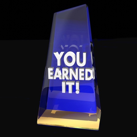 Preisverleihung mit Aufschrift "You Earned It" auf schwarzem Hintergrund. Symbolfoto