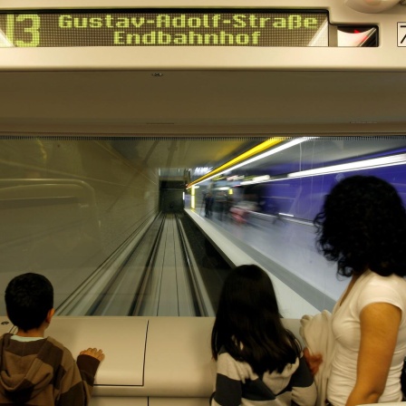 An der Frontscheibe mit direktem Blick auf die Tunnelstrecke steht ein Frau mit ihren zwei Kindern in Nürnberg in der ersten vollautomatischen U-Bahn