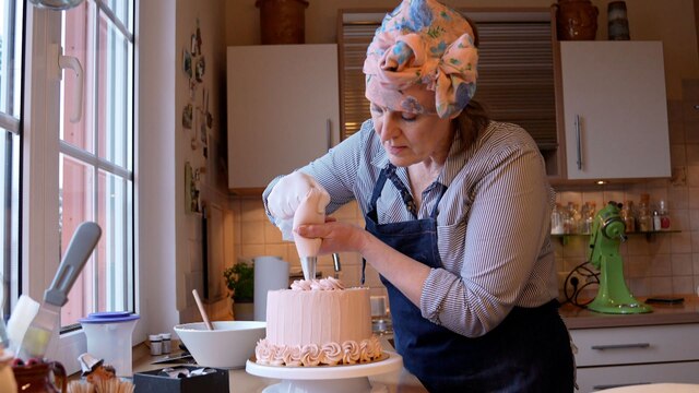 Foto: Eine Frau verziert eine Torte