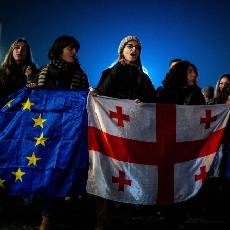 Demonstranten tragen europäische und georgische Flaggen