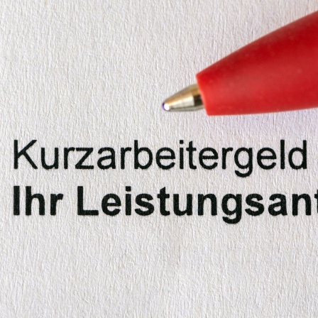 Ein roter Stift liegt auf einem einem Antrag für Kurzarbeitergeld (Kug) der Bundeagentur für Arbeit.