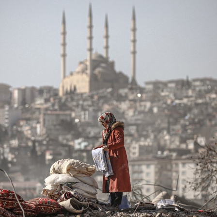 Eine Frau auf den Trümmern eines Hauses in der Türkei