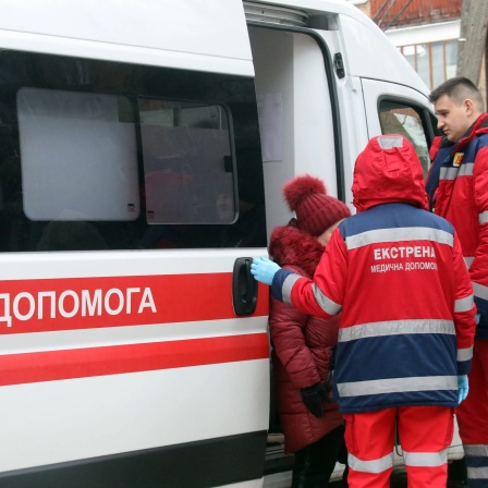 Sanitäter leisten Hilfe für eine Frau, die bei einem russischen Raketenangriff verletzt wurde